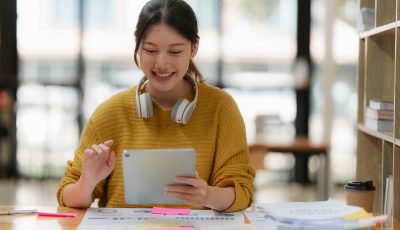 Attractive female student learning language, watching online webinar, listening audio course, e