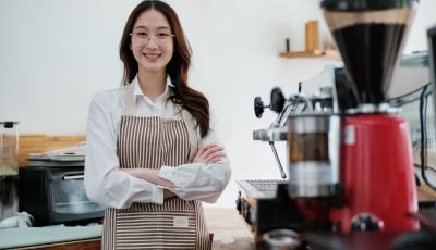 Confident small business owner at a cafe counter, radiating professionalism and hospitality.