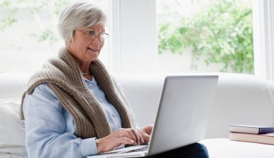 Smiling older woman using laptop